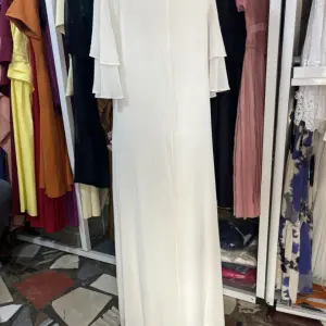 White Maxi Dress featuring a distinctive open-back design with decorative horizontal straps and tiered flutter sleeves.(Free Size)