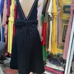 Black Midi Dress in V-neckline on both the front and back, with a prominent oversized bow detail at the waist.