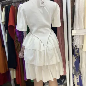 A-line tiered Dress | a Ruffled Shirt Dress with a Lapel Collar and short sleeves, tapering into a multi-layered, tiered skirt that creates a flared, voluminous silhouette.