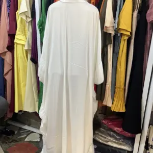 White Kaftan Maxi Dress with a distinctive Butterfly or wing-like Silhouette and Decorative patterns.