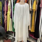 White kaftan-style maxi dress,a loose, flowing silhouette with wide, draped sleeves and a simple round or scoop neckline.