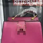 Hermès Constance Bag Trapezoidal shape, a prominent "H" clasp on the front, and a Single Top Handle with distinctive gold-tone hardware.