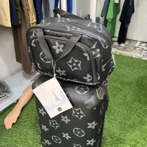 Travel Set includes a Rolling Suitcase and a Smaller Matching Bag, that Showcases Black and White star and monogram pattern