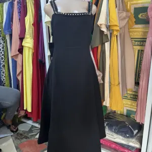 Black Midi Dress in V-neckline on both the front and back, with a prominent oversized bow detail at the waist.