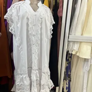 White Cotton Lace Kaftan or Maxi Dress, with Silhouette, tiered Ruffles, and intricate lace detailing.