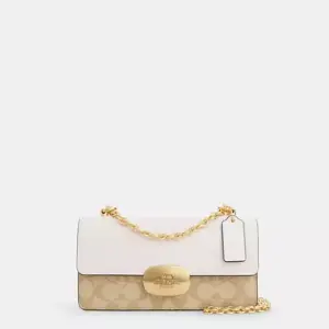 Coach Eliza Flap Crossbody Bag in Signature Canvas, with a light khaki and chalk color combination and a metal chain strap.