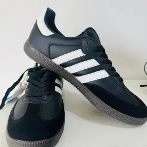 Adidas Samba Sneakers, in a classic three-stripe design and Gum Rubber Outsole.