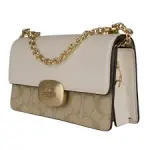 Coach Eliza Flap Crossbody Bag in Signature Canvas, with a light khaki and chalk color combination and a metal chain strap.