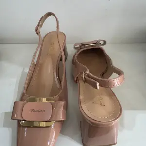 Nude patent leather slingback pumps, in a square toe and block heel, similar to Aaron Fairy