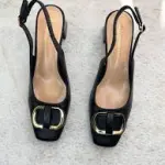 Black buckled slingback block heels pump with a gold-tone buckle .