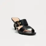 Pointed-toe heeled mules in a smooth black leather double-strap design with a prominent buckle on the upper strap and a stiletto heel.