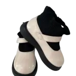Black and cream chunky-soled Mary Jane flats in a contrast design with a strap and thick platform sole.