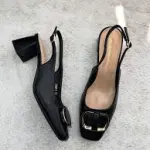 Black buckled slingback block heels pump with a gold-tone buckle .