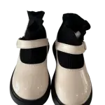 Black and cream chunky-soled Mary Jane flats in a contrast design with a strap and thick platform sole.