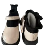 Black and cream chunky-soled Mary Jane flats in a contrast design with a strap and thick platform sole.