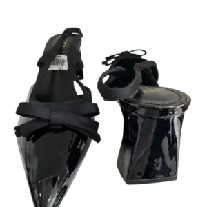 Black patent slingback block pump heels in a pointed toe and bow accent.